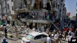 Pakistan's troops and rescue workers look for survivors in the rubble following the explosion, in Karachi, Pakistan, Oct. 21, 2020. 