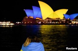 Sydney Opera House yang diterangi dengan warna Bendera Ukraina untuk menandai satu tahun sejak invasi Rusia ke Ukraina dimulai, di Sydney, Australia, 24 Februari 2023. Australia melarang Rusia untuk membangun gedung kedutaan baru di dekat Gedung Parlemen. (Foto: REUTERS/ Joy Jaimi)