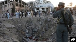  In this Wednesday, May 31, 2017 file photo, security forces stand next to a crater created by a massive explosion, that killed over 150 according to the Afghan president, in front of the German Embassy in Kabul.