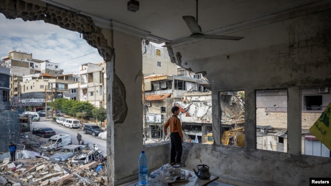 Seorang anak laki-laki berdiri di dalam rumahnya yang rusak akibat serangan Israel setelah gencatan senjata antara Israel dan Hizbullah di Tyre, Lebanon, Jumat, 29 November 2024. (Foto: Adnan Abidi/Reuters)