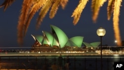 Wisatawan mengabadikan suasana di sekitar Sydney Opera House yang berhiaskan cahaya hijau dalam perayaan Hari Santo Patrick di Sydney (17/3).