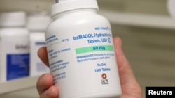 FILE - A pharmacist holds a bottle of traMADOL Hydrochloride made by Sun Pharma at a pharmacy in Provo, Utah, May 9, 2019.