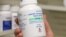 FILE - A pharmacist holds a bottle of traMADOL Hydrochloride made by Sun Pharma at a pharmacy in Provo, Utah, May 9, 2019.
