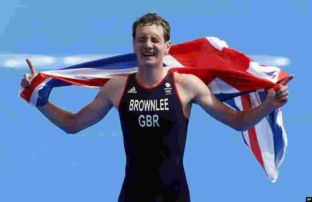 Great Britain's Alistair Brownlee reacts as he crosses the finish line to win the gold medal in the men's triathlon at the 2012 Summer Olympics, Aug. 7, 2012, in London. 