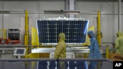 FILE - Employees work at the Adani New Industries Limited, one of India's largest solar panels and wafers manufacturing facility in the port town of Mundra in Western India's Gujarat state, India, September 20, 2023.