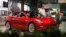 FILE- In this July 6, 2018, file photo, a prospective customer confer with sales associate as a Model 3 sits on display in a Tesla showroom in the Cherry Creek Mall in Denver. 