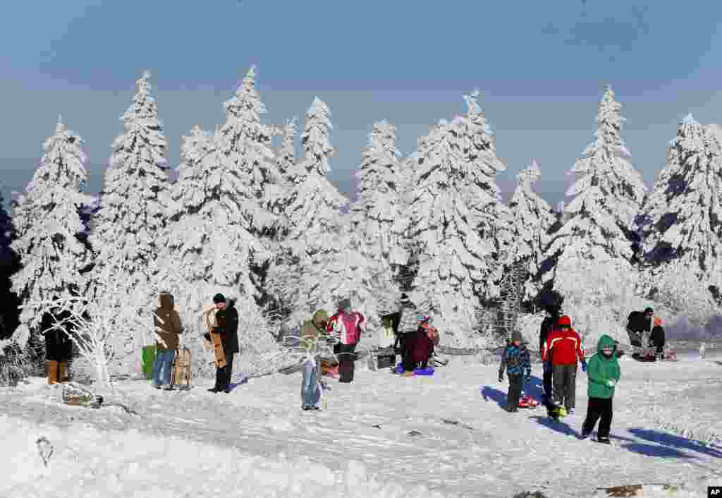 Trees are covered with snow as people go for sleding or a walk on top of the Feldberg mountain near Frankfurt, Germany.