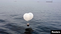 Sebuah balon yang membawa berbagai benda termasuk sampah, yang diyakini dikirim oleh Korea Utara, terlihat di laut lepas Incheon, Korea Selatan, 9 Juni 2024. (Foto: Yonhap via REUTERS)