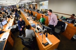 FILE - Personnel at the the Centers for Disease Control and Prevention work at the Emergency Operations Center in response to the 2019 novel coronavirus, Feb. 13, 2020, in Atlanta.