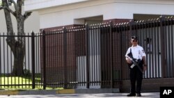 Un policía salvadoreño hace guardia frente a la principal entrada de la embajada de EE.UU. en San Salvador, El Salvador.