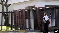 Un policía salvadoreño realiza guardia frente a la embajada de EE.UU. en San Salvador.