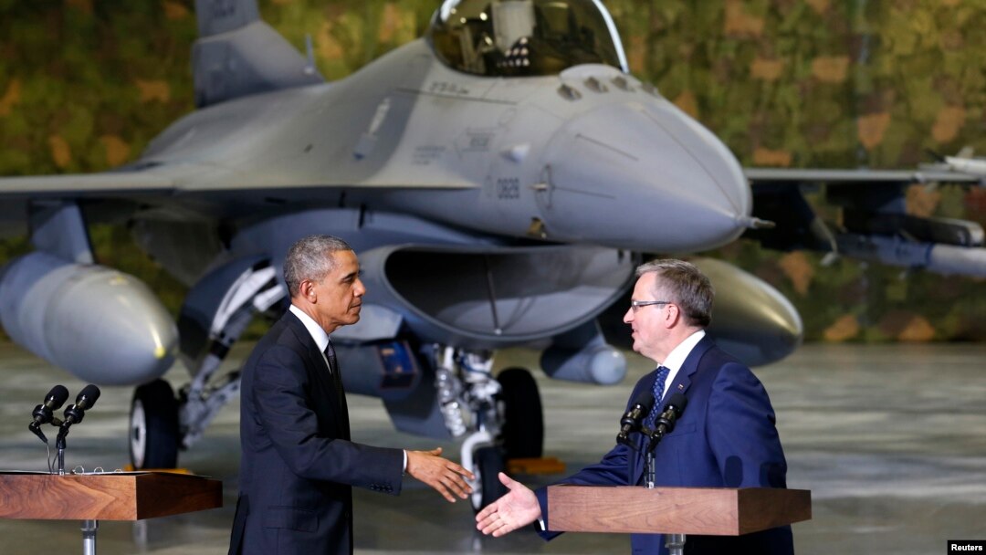 Presiden AS Barack Obama (kiri) dan Presiden Polandia Bronislaw Komorowski saat penyambutan di bandara Chopin, Warsawa dengan pesawat F-16 di latar belakang (3/6).