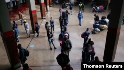 Pasajeros con mascarillas protectoras hacen fila en la boletería de la terminal de transporte, en medio del brote de la enfermedad por coronavirus (COVID-19), en Bogotá.