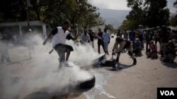 Un policía y un transeúnte intentan apagar el fuego en unos neumáticos iniciado por los manifestantes.