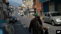 Hombre usa máscara protectora como precaución contra la propagación del coronavirus mientras camina en el barrio de Lidice de Caracas, Venezuela.