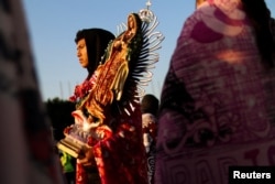 A pilgrim carries an image of the Virgin during the annual Virgin of Guadalupe feast day, in Mexico City, Dec. 12, 2024.