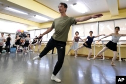 Du Hai, center, a Chinese ballet dancer who has made Japan his home, teaches a class at a studio in Ichikawa, east of Tokyo, Japan, Saturday, Aug. 10, 2024. (AP Photo/Shuji Kajiyama)