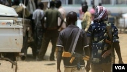 Beberapa pria bersenjata berjalan di kota minyak, Abyei di Sudan Selatan (foto: April 2011).