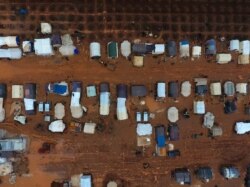 FILE - An aerial photo shows tents sheltering Syrians who fled battles in the southern and eastern countryside of Syria's Idlib province, surrounded by mud, in a camp for displaced people near Sarmada near the Turkish border, Dec. 29, 2019.