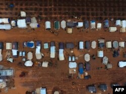 FILE - An aerial photo shows tents sheltering Syrians who fled battles in the southern and eastern countryside of Syria's Idlib province, surrounded by mud, in a camp for displaced people near Sarmada near the Turkish border, Dec. 29, 2019.