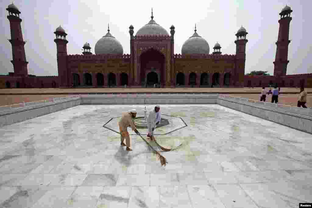 Para pekerja membersihkan masjid Badshahi di Lahore, Pakistan, menjelang Ramadan (9/7). (Reuters/Mohsin Raza)