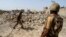 FILE - Pakistani soldiers stand near the debris of a house which was destroyed during a military operation against Taliban militants in the town of Miranshah in North Waziristan, July 9, 2014. 