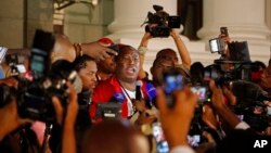 South African Economic Freedom Fighters leader Julius Malema, center, speaks after he and other members leave parliament's opening session in Cape Town, South Africa, Feb. 12, 2015.