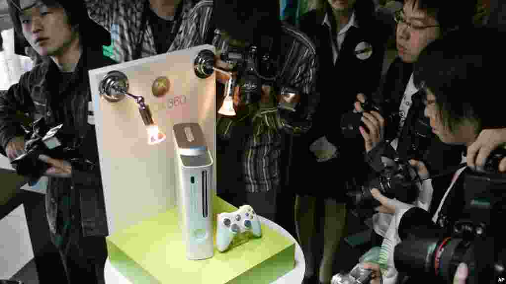 Photographers surround the console of next generation video game and entertainment machine Xbox 360 during an unveiling in Tokyo, Japan, May 13, 2005.