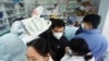 Orang-orang mengantre untuk membeli alat tes antigen COVID-19, di sebuah apotek di Hangzhou, Provinsi Zhejiang, China, 19 Desember 2022. (Foto: China Daily via REUTERS)