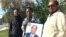 Family members from left, Fobel Tekleab, Fessehatsion Gebreselassie and Abraham Amanios, hold a photo of Isaac Amanios, Dec. 5, 2015.
