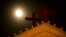 FILE - The moon rises above a pair of crosses on the roof of Holy Trinity Church in Wenzhou in eastern China's Zhejiang Province.
