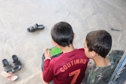 Maher plays video games as his brother looks on, in Khanke, Kurdistan region, Iraq, Sept. 28, 2019. The boys were kidnapped nearly five years ago and sold to separate buyers. (Heather Murdock/VOA)