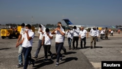 FILE - Guatemalan migrants walk on the tarmac after being deported from the U.S., at La Aurora International Airport in Guatemala City, Nov. 21, 2019.