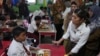 Indonesian Minister of Information and Digital Affairs Meutya Hafid, right, at an elementary school in Depok, West Java, Indonesia, Jan. 6, 2025. She said on Jan. 15, 2024, that the government planned to issue a regulation to set a minimum age for social media users.