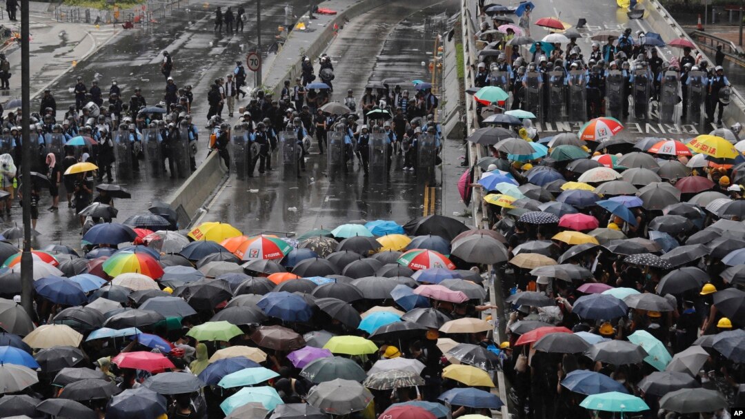 Para pengunjuk rasa menggunakan payung untuk menghadapi polisi anti huru-hara di Hong Kong, Senin, 1 Juli 2019. (Foto: AP)