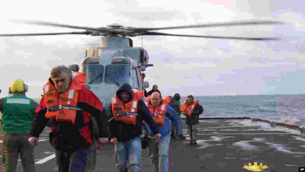 In this image released by the Italian Navy, passengers and crew of the Italian-flagged Norman Atlantic, that caught fire in the Adriatic Sea, are rescued from the Italian Navy ship San Giorgio, Dec. 29, 2014. 