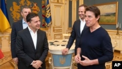 Ukrainian President Volodymyr Zelenskiy, left, and American actor, film director and producer Tom Cruise talk during their meeting in Kyiv, Ukraine, Sept. 30, 2019. 
