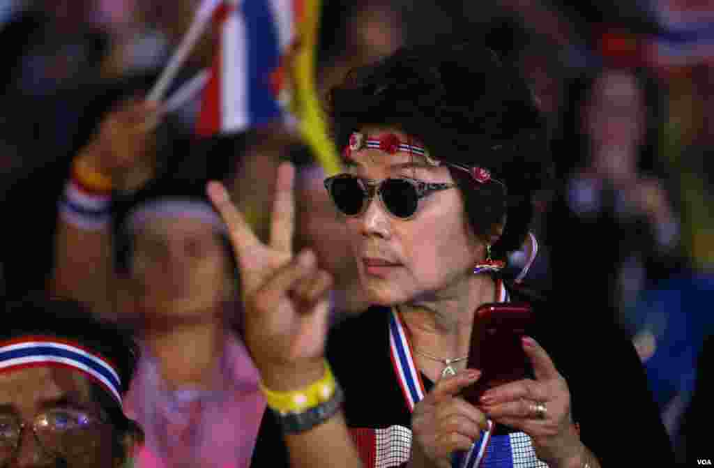 An anti-government protester looks at other protesters during an evening rally at the Democracy monument, Bangkok, Thailand, Dec. 15, 2013. 