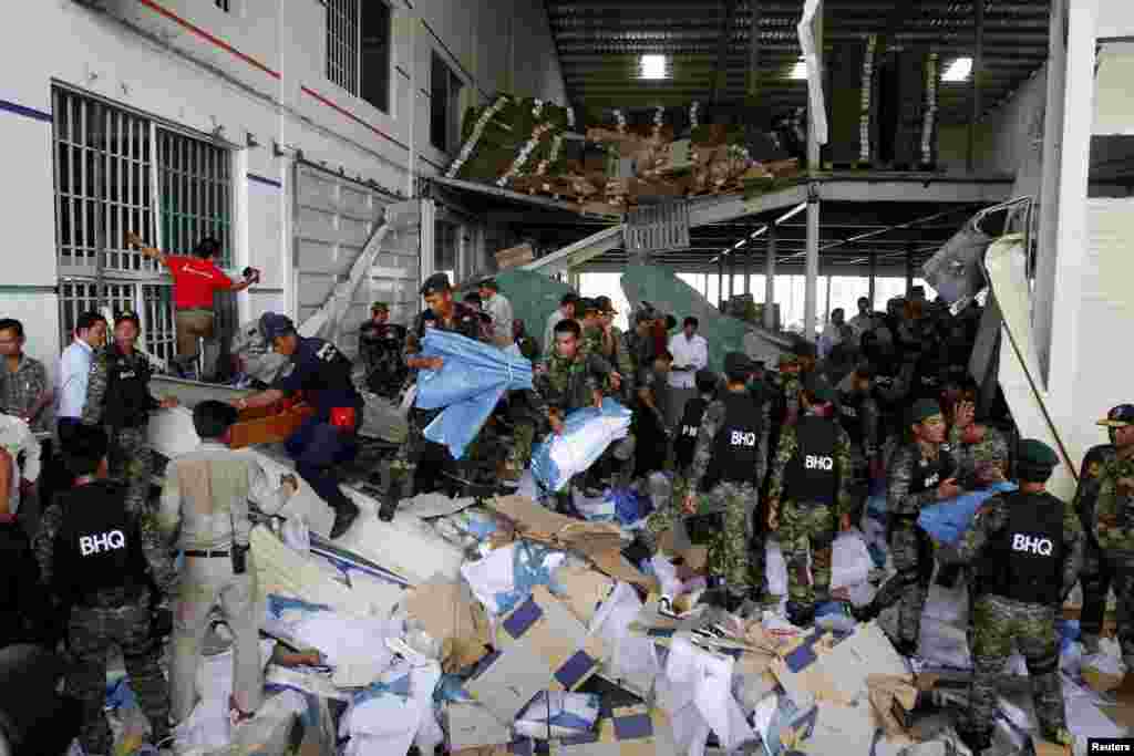 Rescue workers and soldiers search through a site of the accident in a shoe factory in Phnom Penh, May 16, 2013.