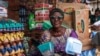 FILE - Mrs Bakare Kehinde, a retired principal, holds various types of plastic plates in her store in Lagos, on January 23, 2024. 