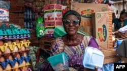 FILE - Mrs Bakare Kehinde, a retired principal, holds various types of plastic plates in her store in Lagos, on January 23, 2024. 