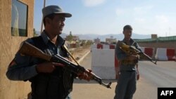 Afghan policemen keep watch at the scene following a suicide attack in Mazar-i-sharif, Oct. 12, 2014. 