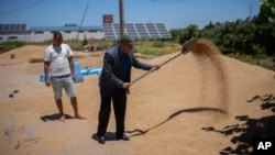 Abdelkrim Naaman, the chairman of the NGO Nalsya, right, advises a farmer on seeding, irrigation and drought mitigation, on a farm on the outskirts of Kenitra, Morocco, June 21, 2024.