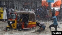 A man attempts to rescue a boy from raging flood waters following heavy rains in Mogadishu, Somalia November 9, 2023.