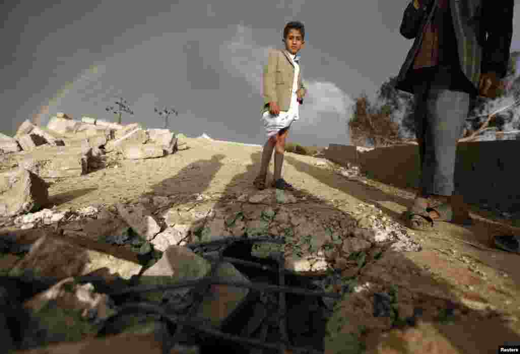 A boy stands on the ruins of his school which was bombed by militants of the Shi&#39;ite al-Houthi group during recent conflicts against local tribes in the Hamdan area west of the Yemeni capital Sanaa, March 23, 2014. 