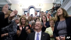 Massachusetts Governor Charlie Baker smiles as he signed a bill into law requiring men and women be paid equally for comparable work in Massachusetts. (AP Photo/Elise Amendola)