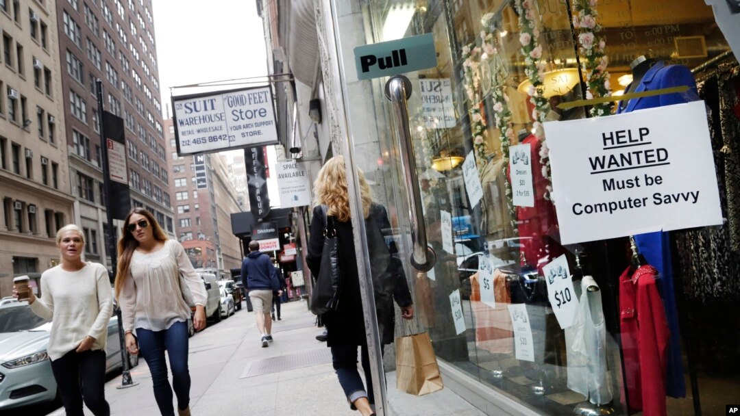 FILE - A "Help Wanted" sign hangs in a store window in New York. 