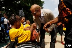 FILE—Prince Harry (R), Duke of Sussex, meets children as he and Britain's Meghan, Duchess of Sussex attend a basketball exhibition training match at Ilupeju Grammar School in Lagos on May 12, 2024 as they visit Nigeria as part of celebrations of Invictus Games anniversary.