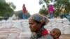 FILE PHOTO: A woman carries an infant as she queues in line for food, at the Tsehaye primary school, which was turned into a temporary shelter for people displaced by conflict, in the town of Shire, Tigray region, Ethiopia, March 15, 2021.