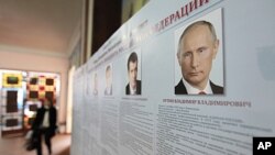 A board with the profiles of various presidential candidates, amongst them Russia's current Prime Minister Vladimir Putin, is on display during the preparations for the upcoming presidential elections at a polling station in the southern Russian city of S